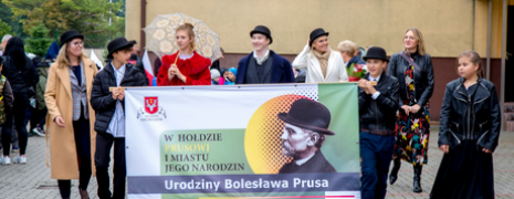 Grupa osób trzyma baner z nazwą wydarzenia