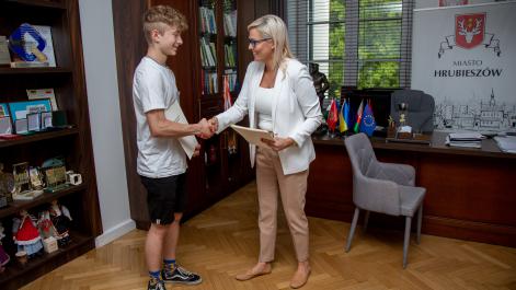 Burmistrz Marta MAjewska gratuluje młodemu zawodnikowi sekcji podnoszenia ciężarów