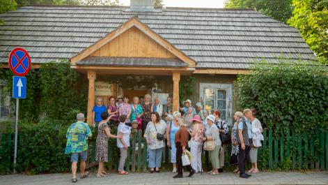 seniorzy pozują do zdjęcia przed domem Wiktora Zina