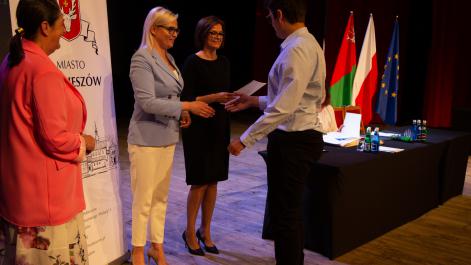 Burmistrz gratuluje nagrody, Monika Podolak sekretarz miasta wręczy za chwilę dyplom stypendyście