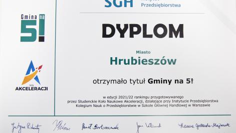 Dyplom pzryznany przez Szkołę Główną Handlową w Warszawie dla miasta Hrubieszów, po lewej stronie loga instytucji prowadzących badanie, na dole podpisy członków komisji
