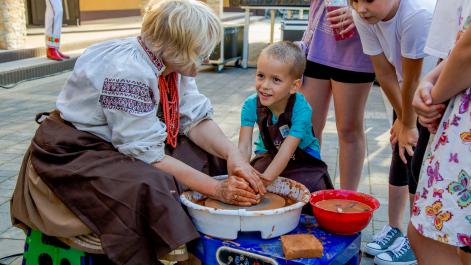 Kobieta uczy dziecko robić garnki z gliny