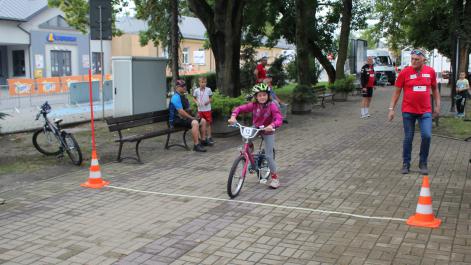 Dziewczynka stoi z rowerem na starcie